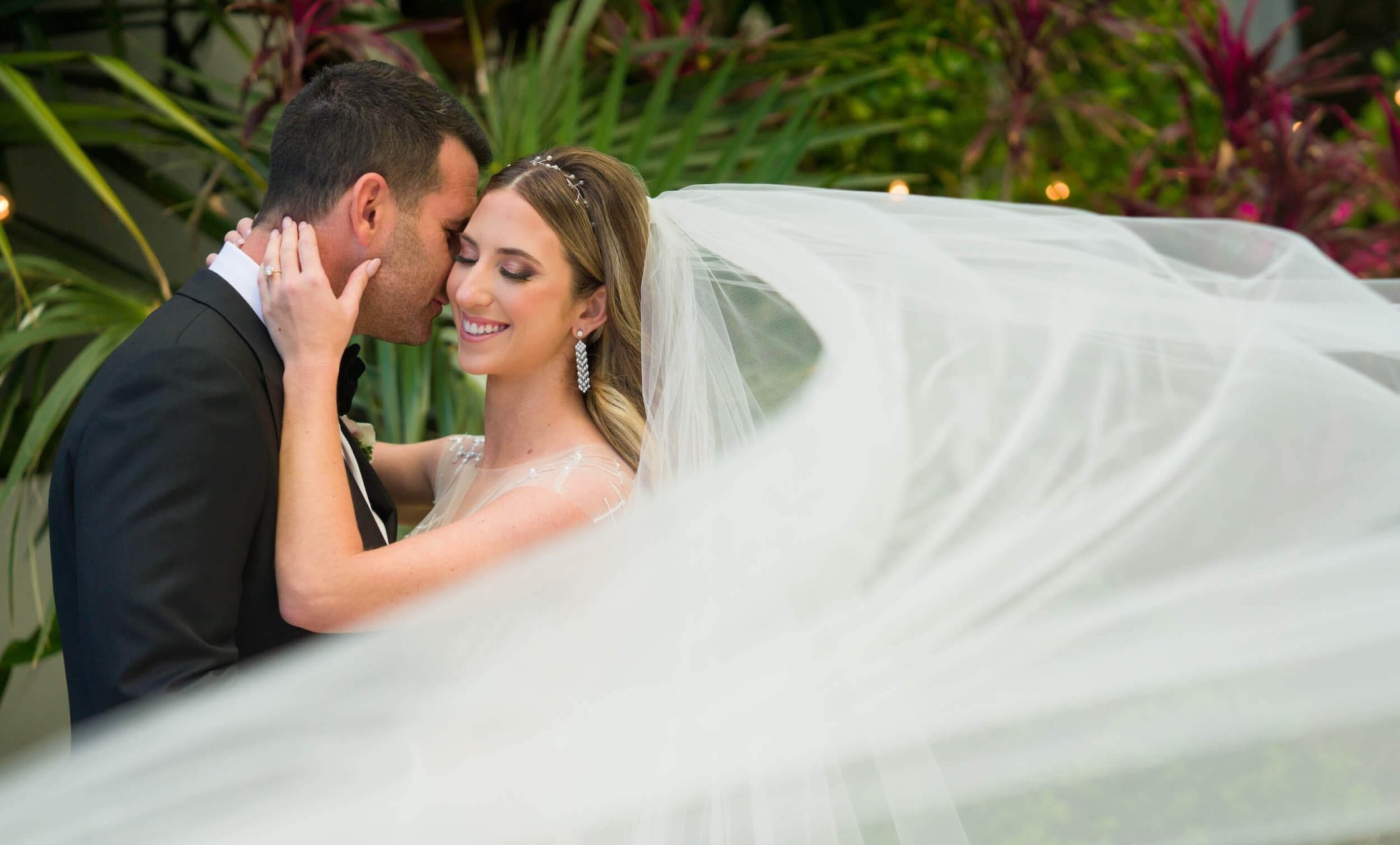 Husband and wife embracing with her veil flowing in front of them