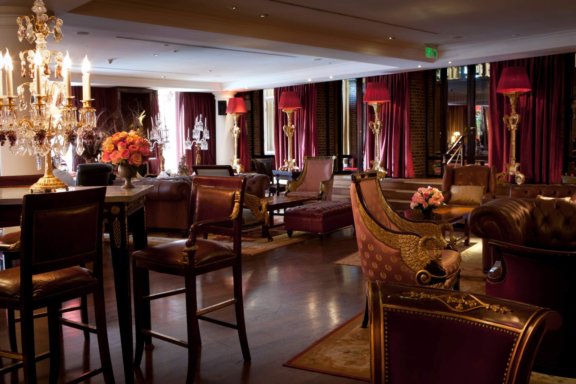 interior of lounge with red curtains, lamps and large candelabra on table