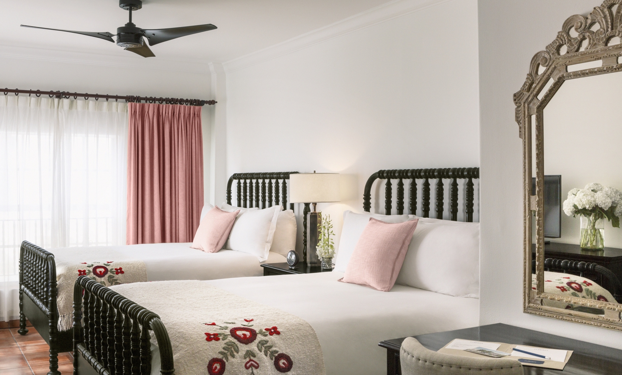 two beds with white sheets with mirror in foreground