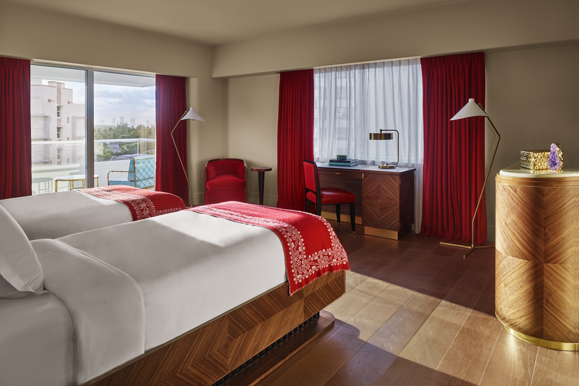hotel bedroom with large windows overlooking city