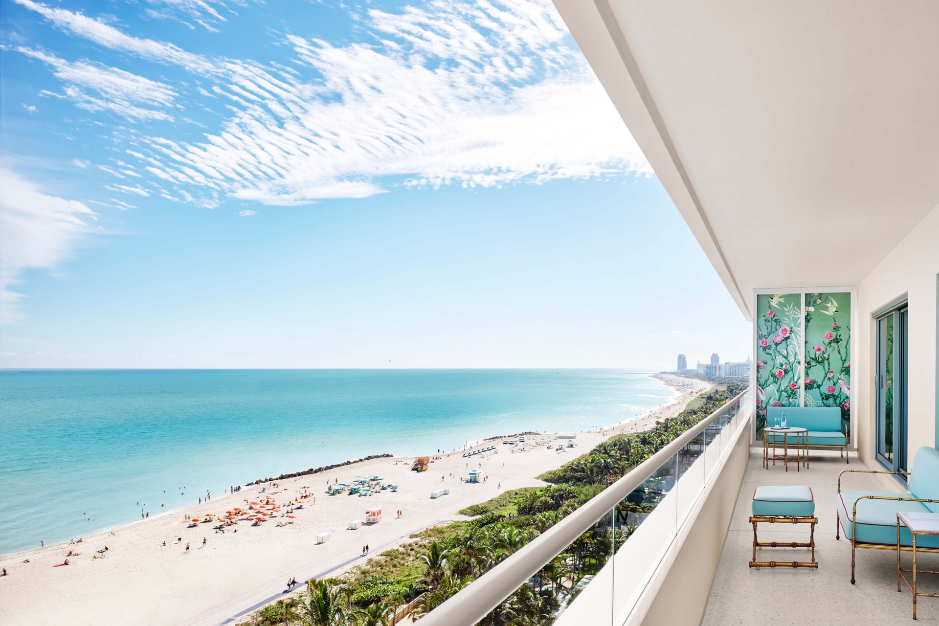 turquoise furniture sits on balcony with beach in the background