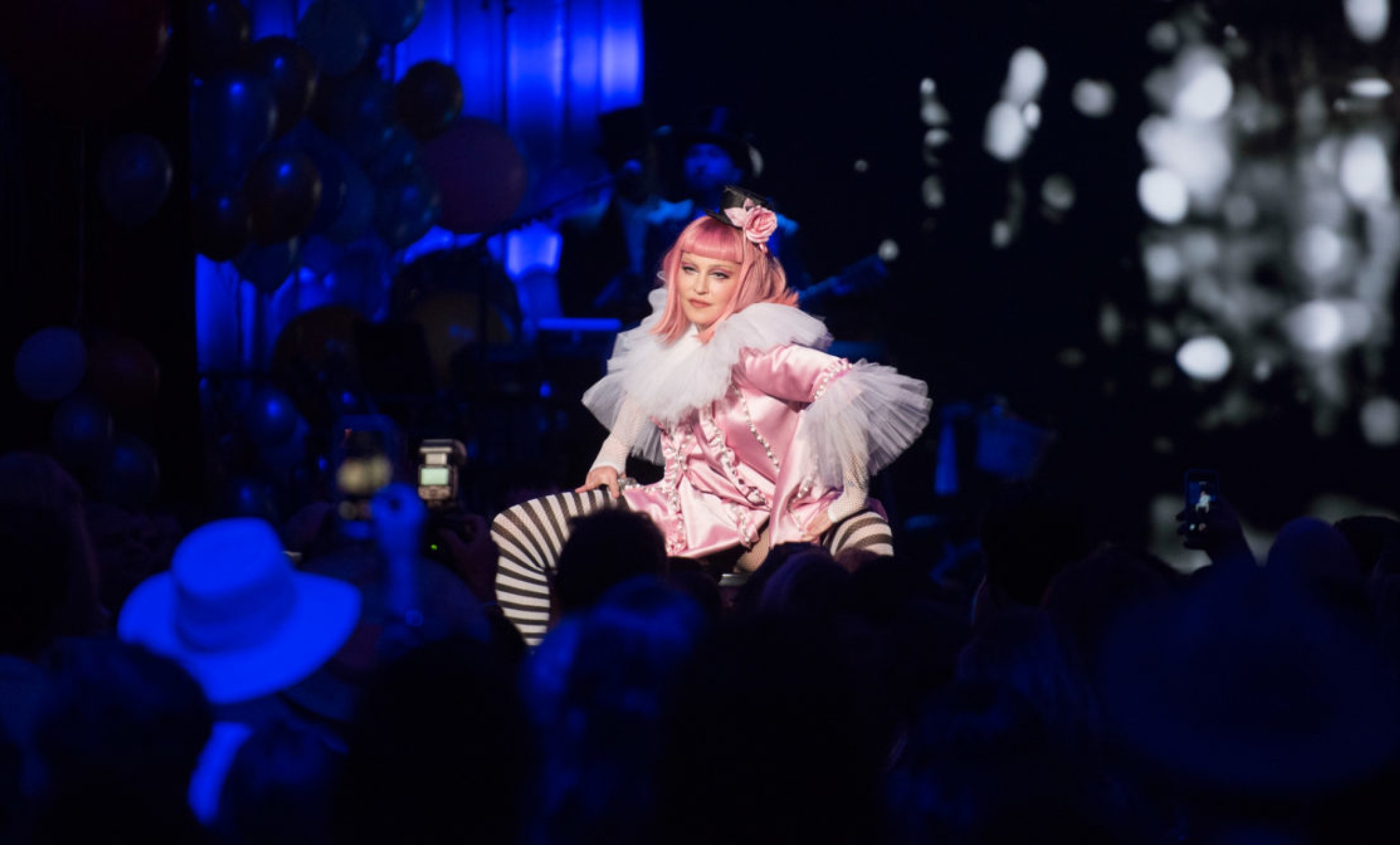 madonna performs on stage wearing pink wig and black & white striped socks