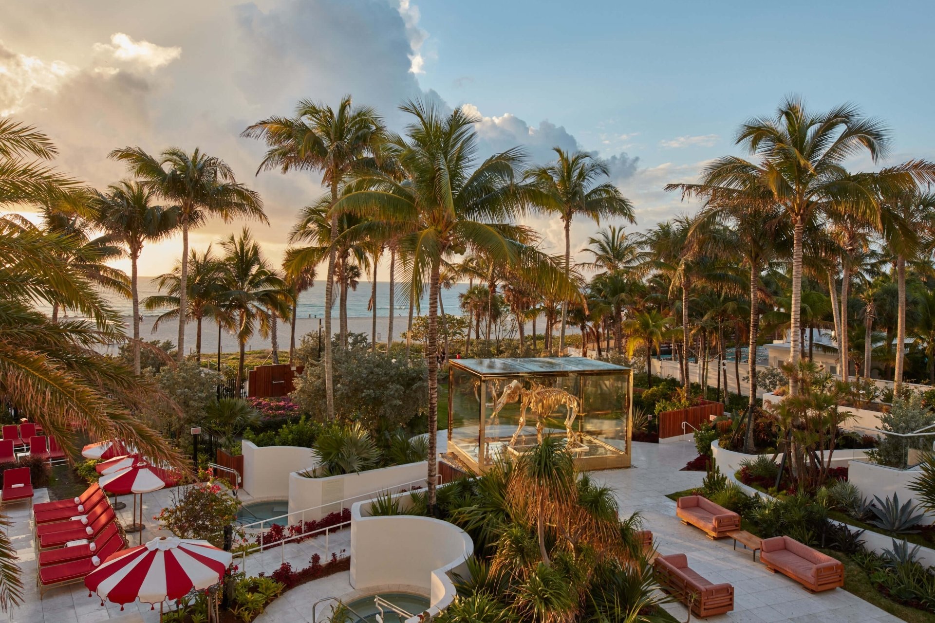wide view of mammoth installation, red and white umbrellas and palm trees along the ocean
