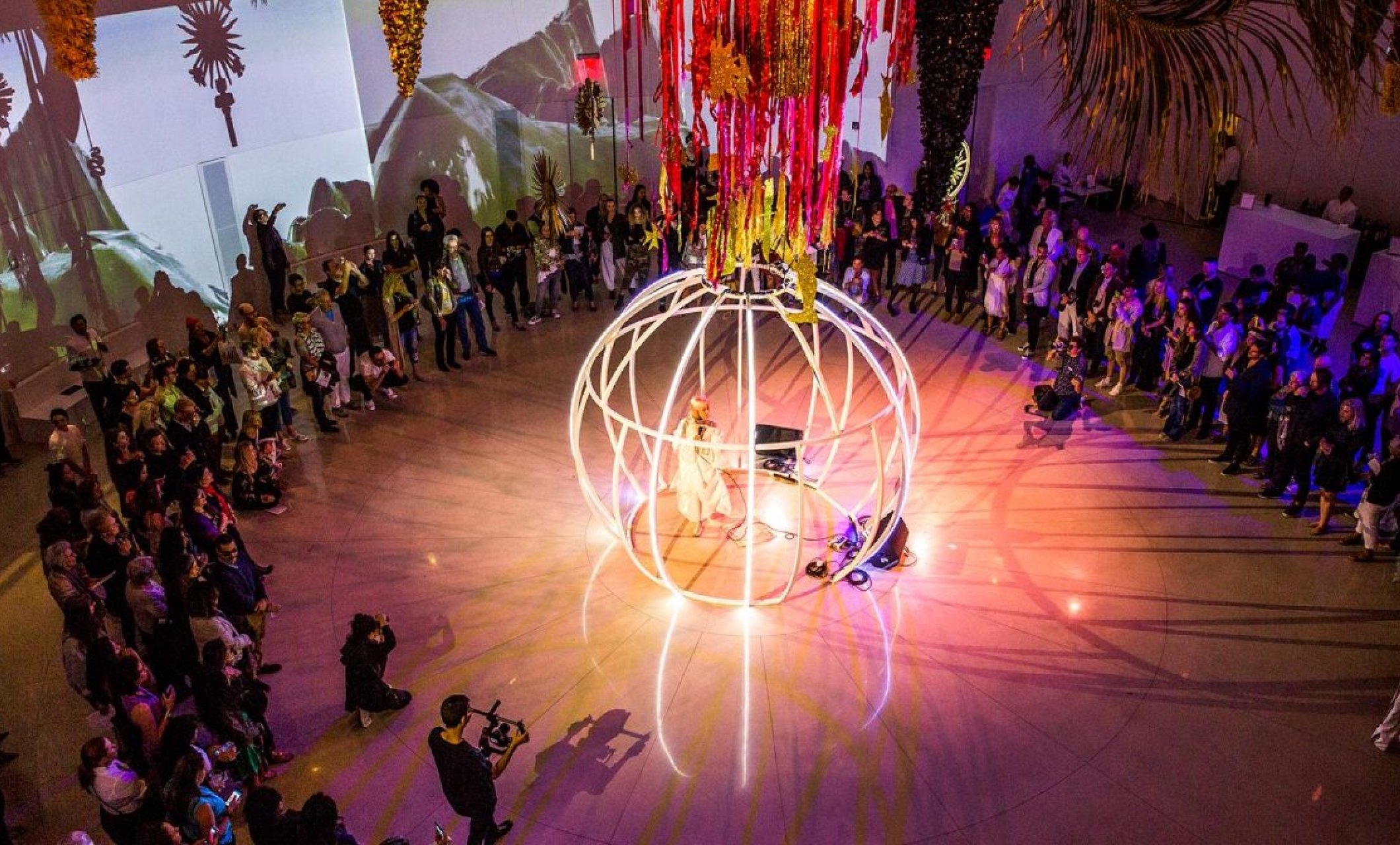 birds eye view of white sphere stage surrounded by group of people