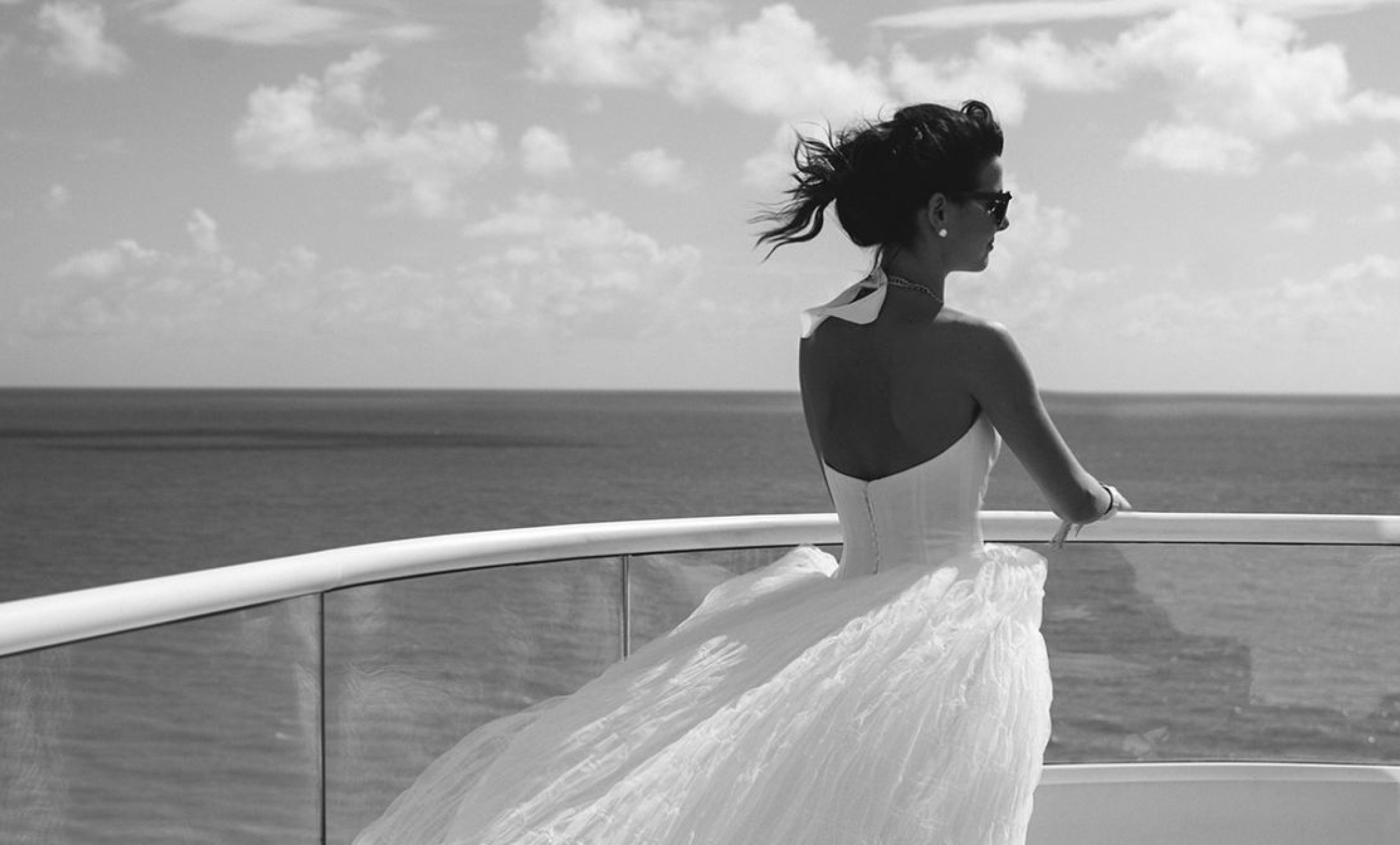 Bride in wedding dress looking out over ocean