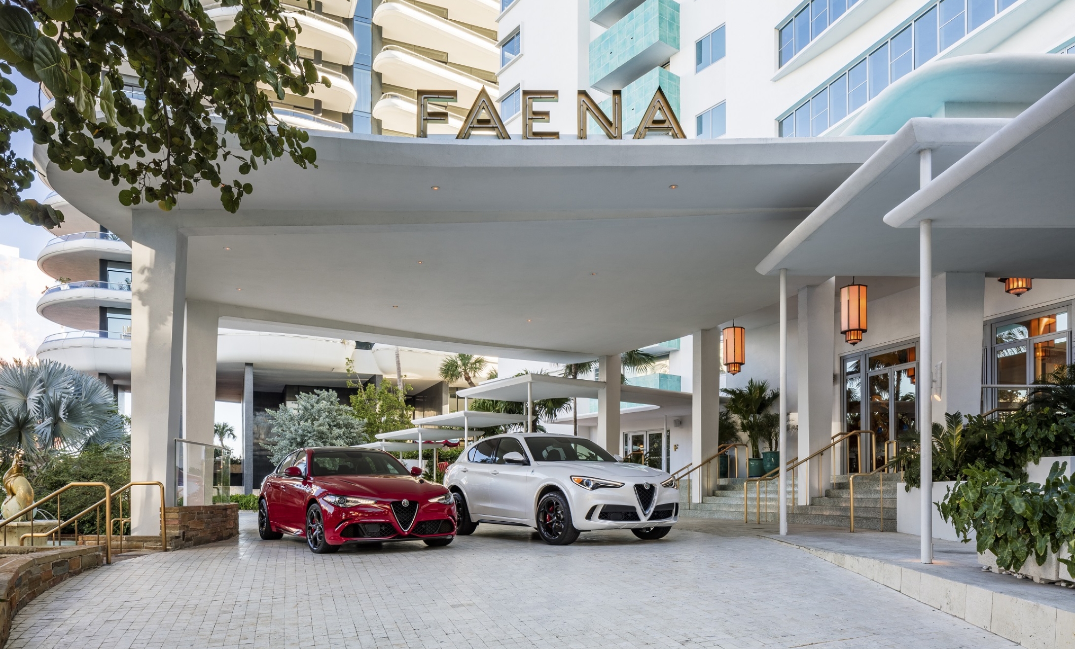 Red and white alfa romeo cars parked in front of Faena hotel