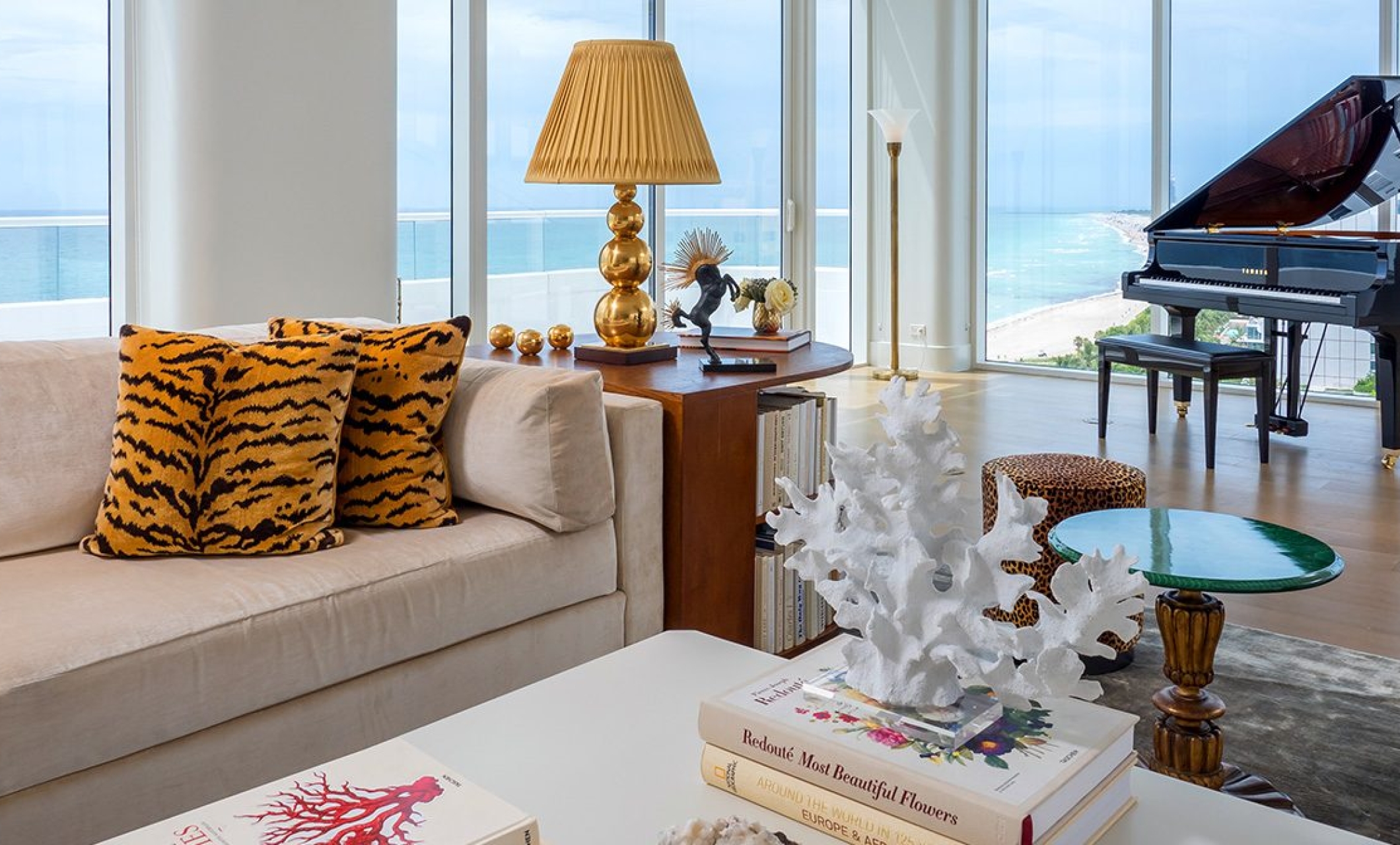 couch in hotel penthouse with grand piano behind