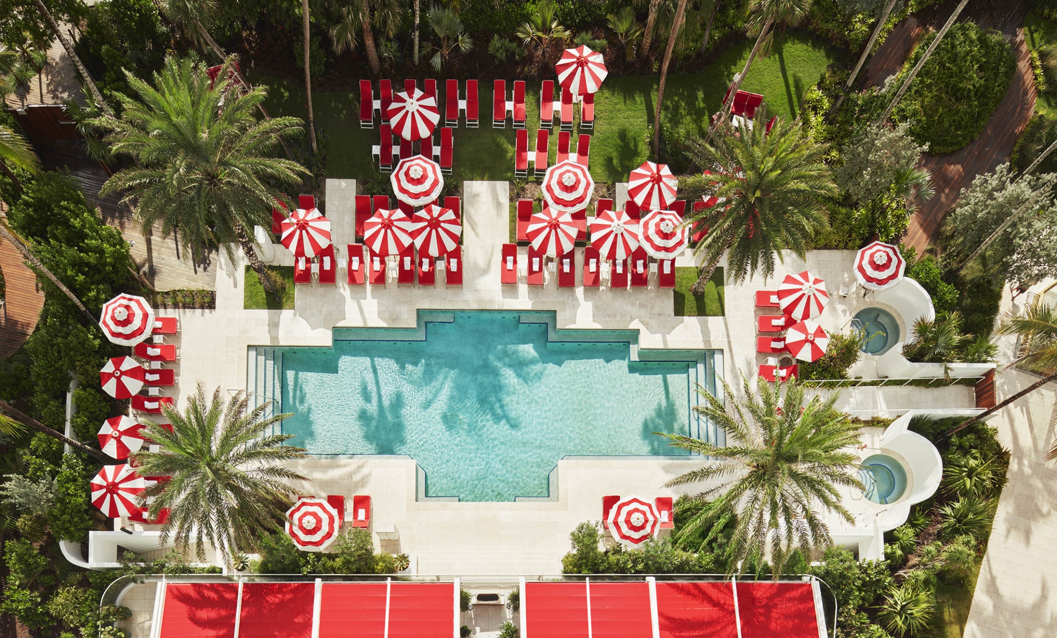 hotel pool with sun umbrellas and palm trees