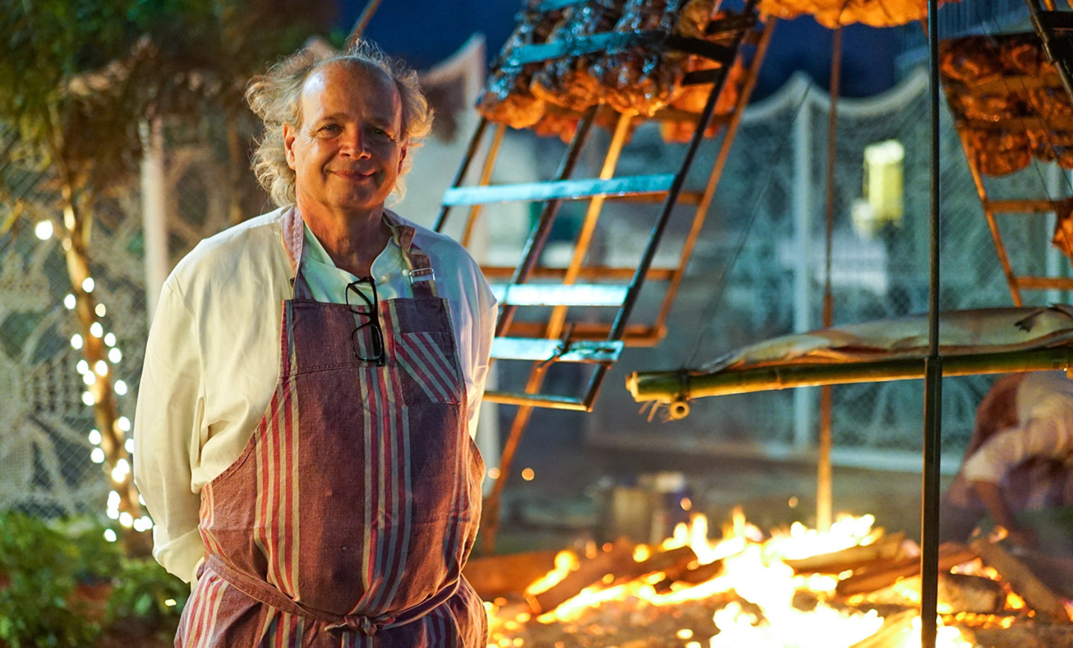 francis mallmann standing in front of open fire cooking