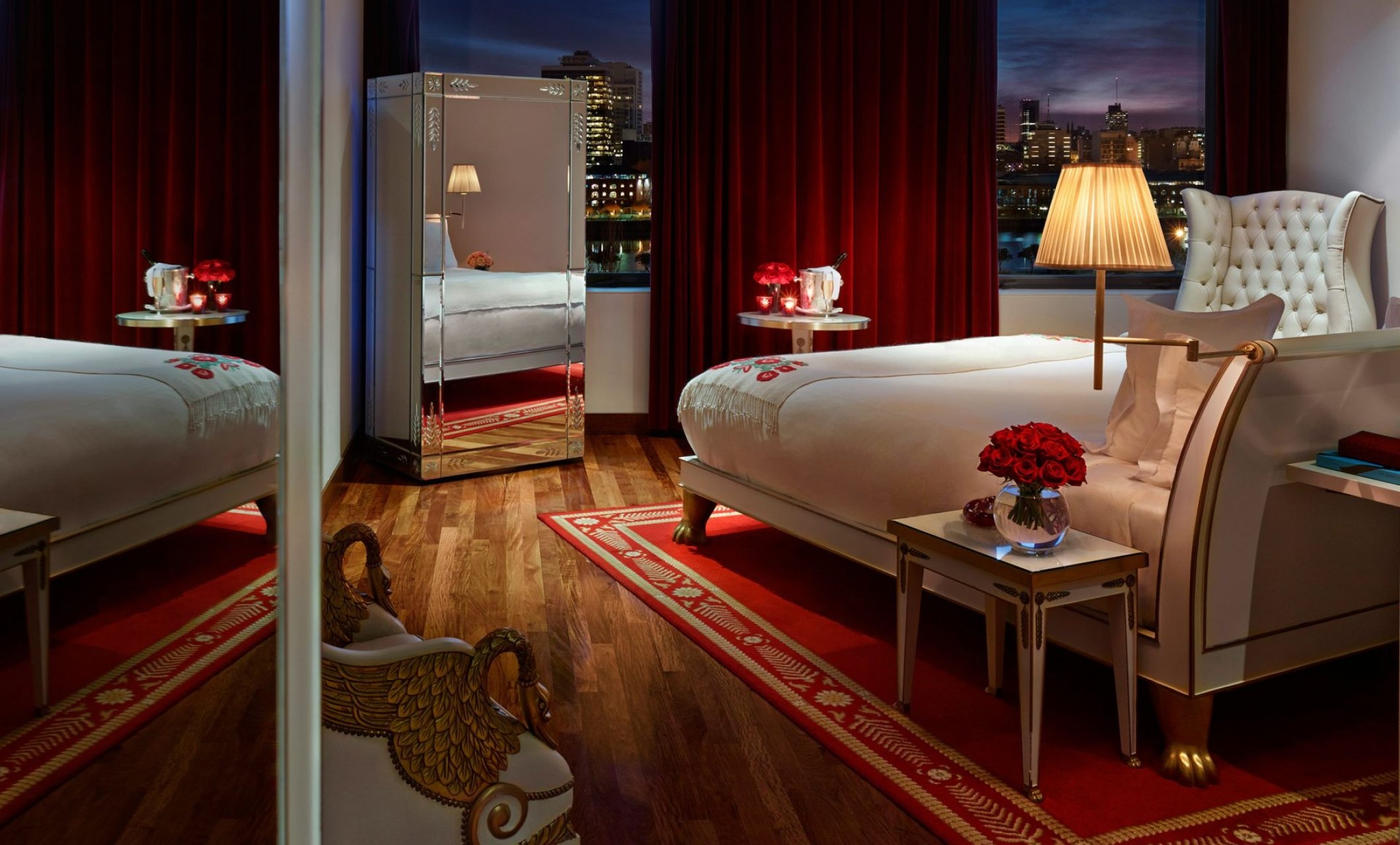 hotel bedroom with large windows overlooking city