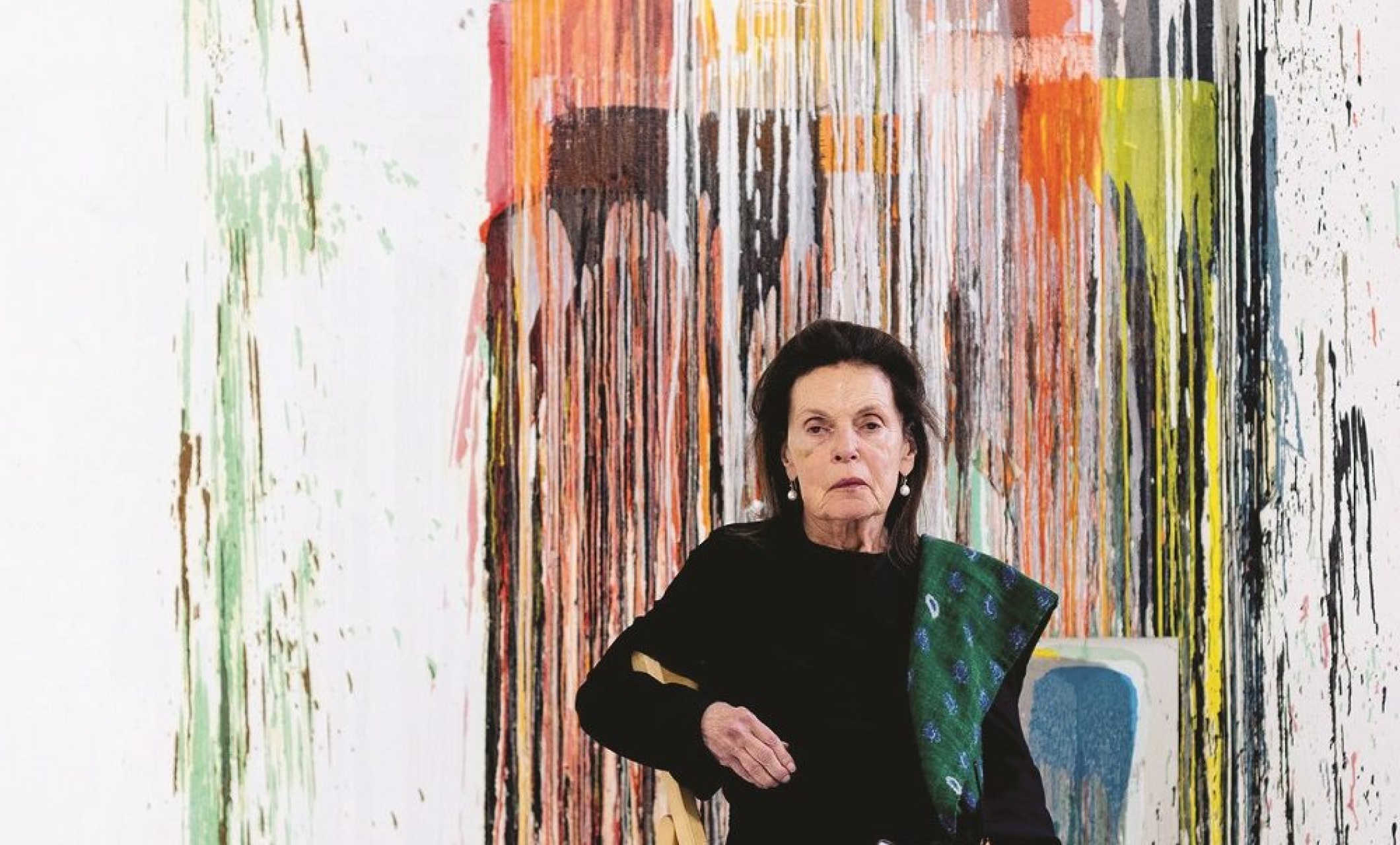 Woman sitting in front of abstract painting
