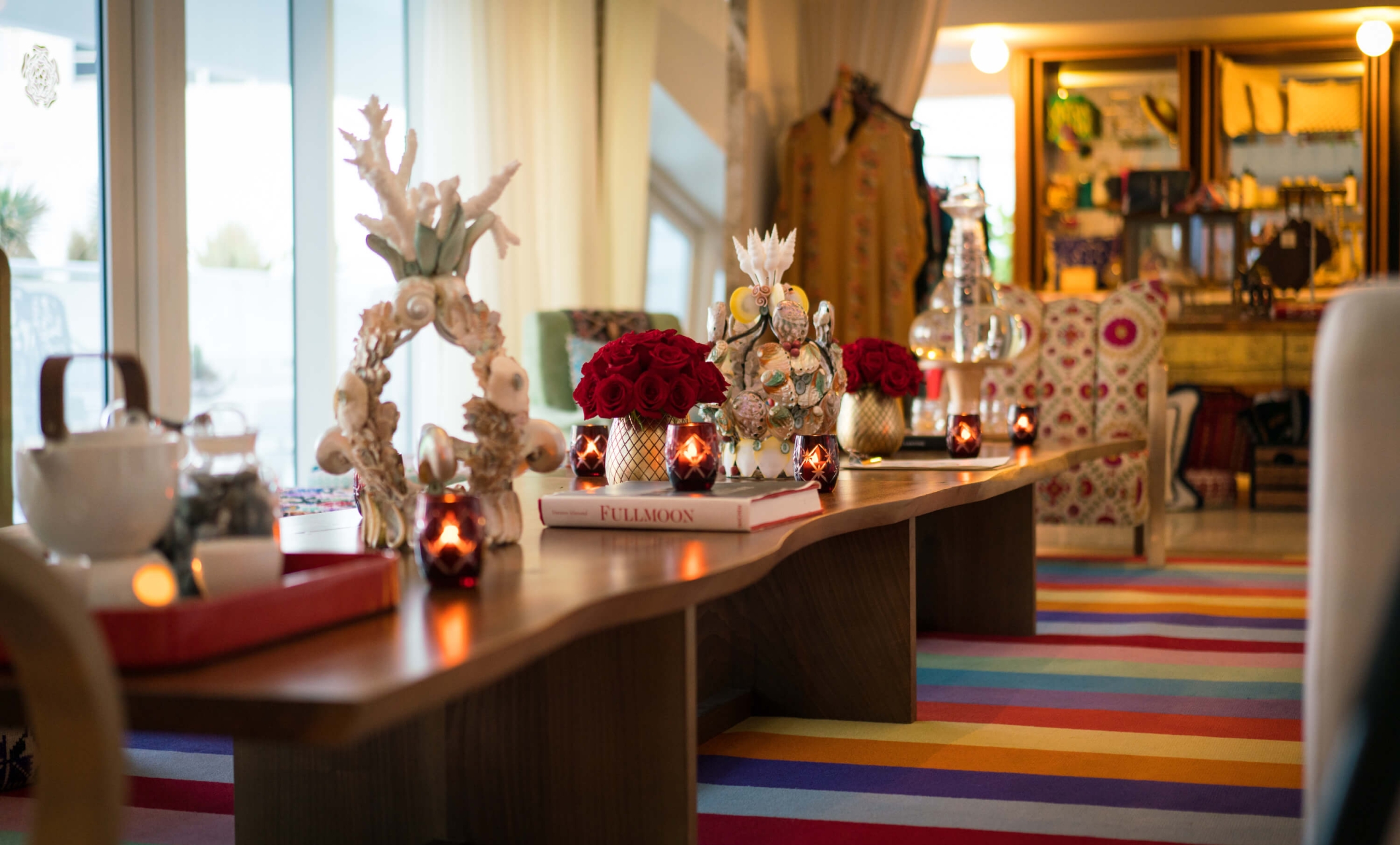 long table with candles and a rainbow rug underneath