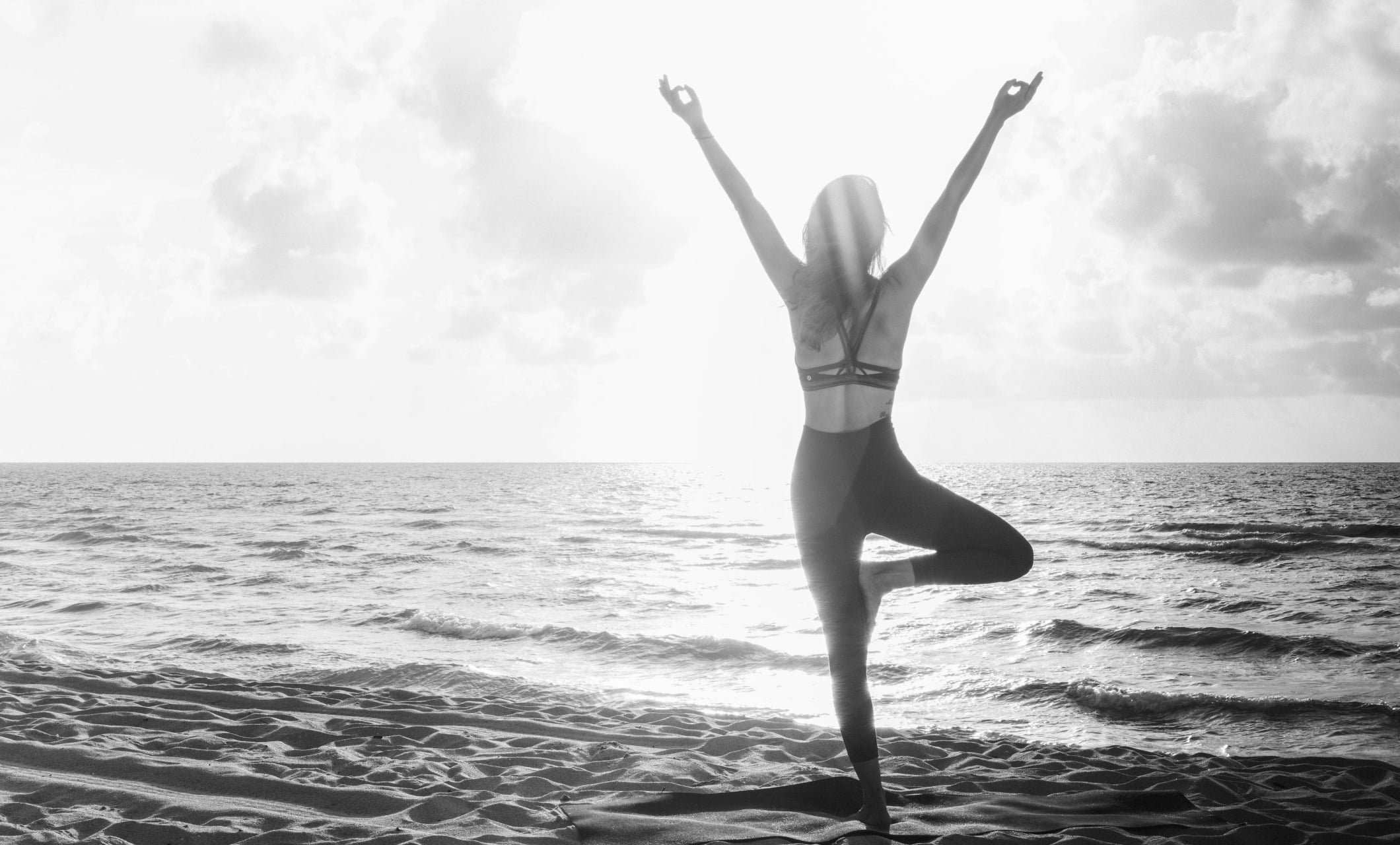 woman on beach holding a yoga pose