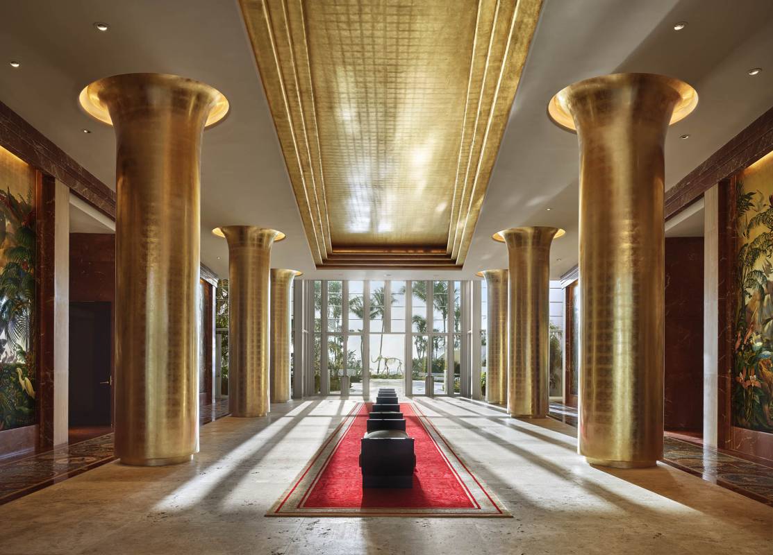 long lobby hallway with six golden columns