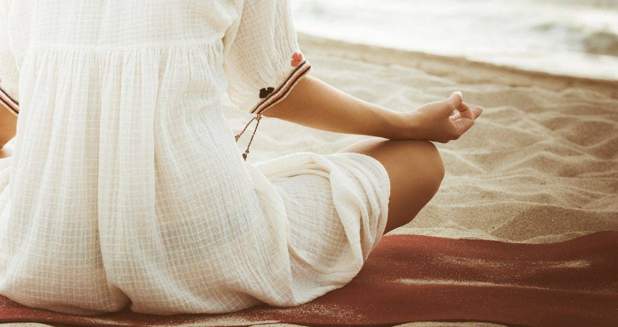 Woman meditating on beach