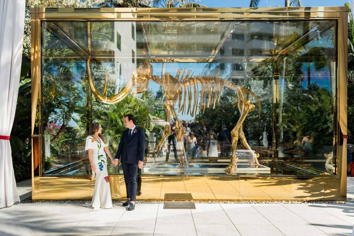 Husband and wife looking at eachother while in front of a large mammoth statue