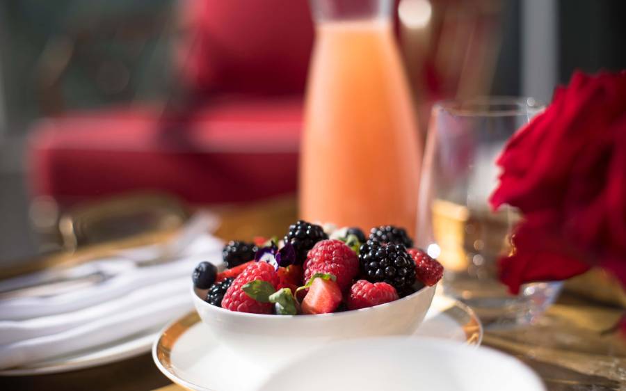 bowl of fruit and carafe of juice sits on table