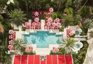hotel pool with sun umbrellas and palm trees
