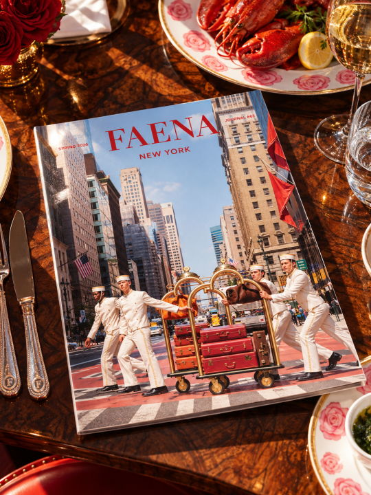 Faena New York Journal magazine displayed on an elegant dining table with lobster, wine, and floral tableware.