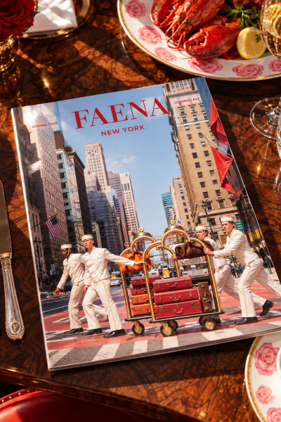 Faena New York Journal magazine displayed on an elegant dining table with lobster, wine, and floral tableware.