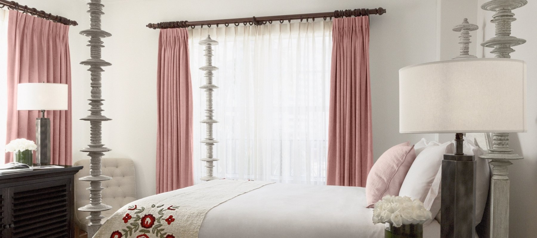 queen bed with four posts and pink curtained windows
