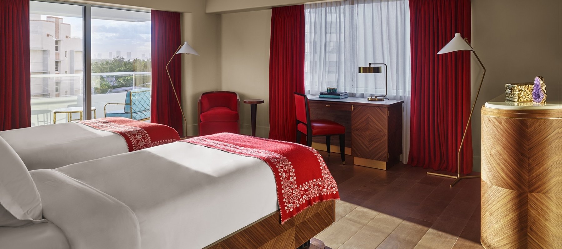 hotel bedroom with large windows overlooking city