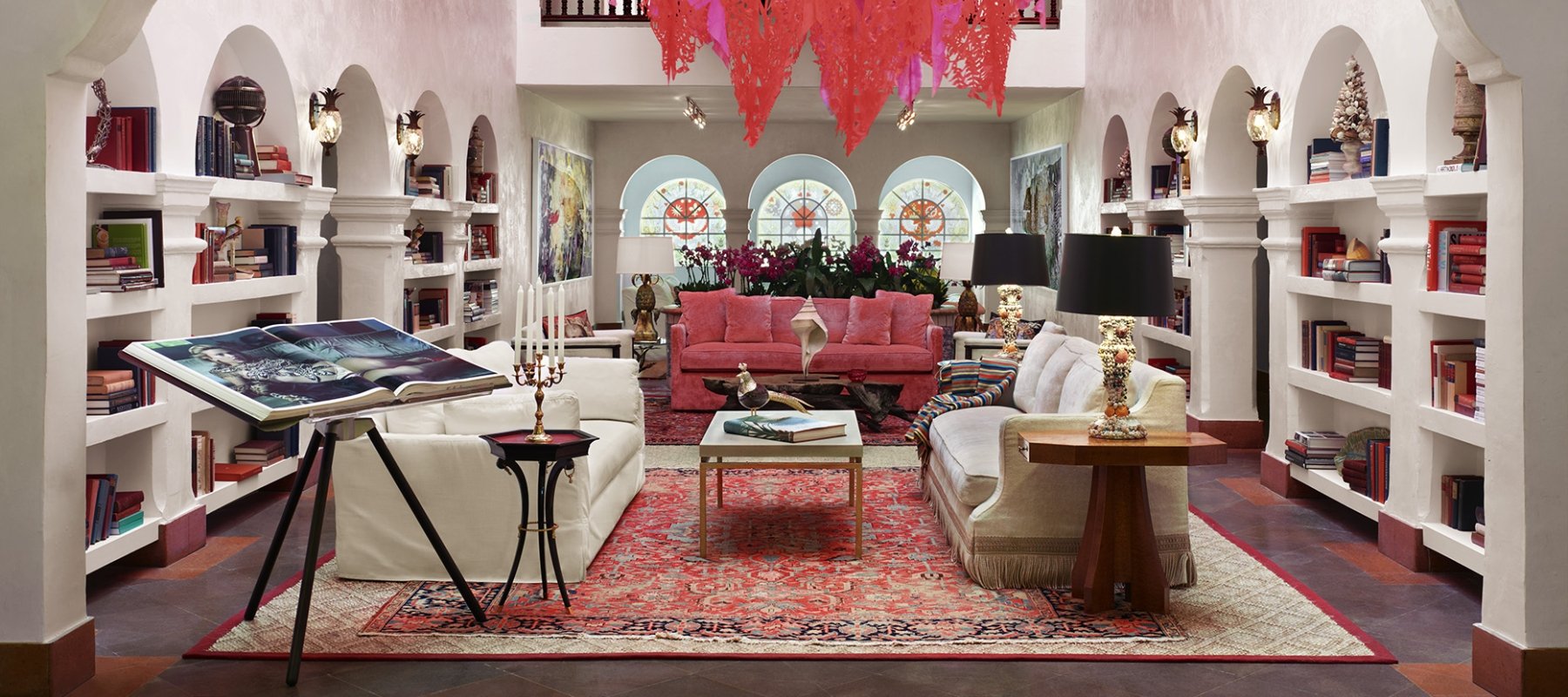 furniture sits on rug in room with red chandelier 