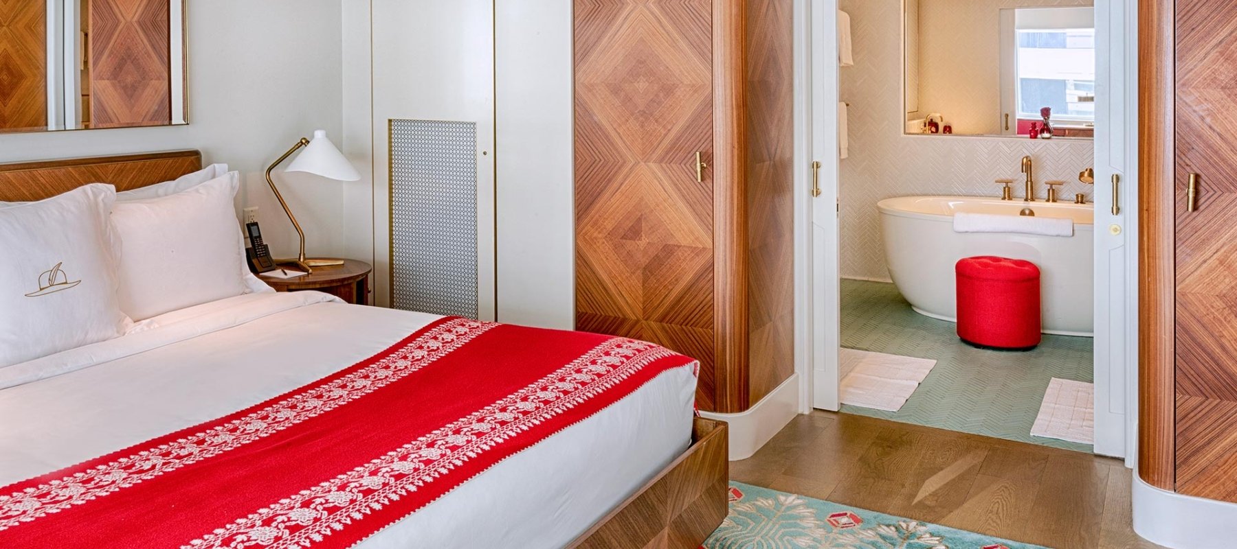 bed with view of bathtub in bathroom in the background