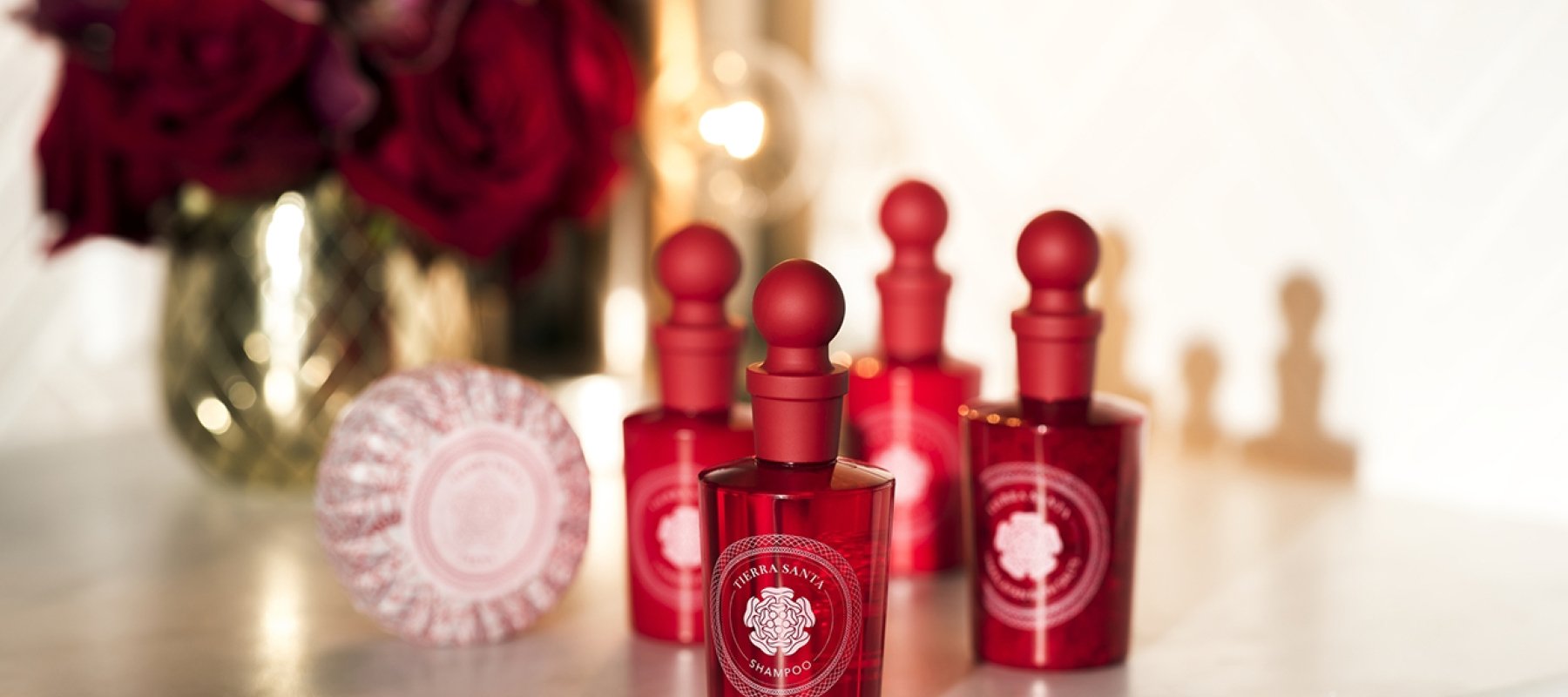 Bath products in red bottles sitting on a white counter