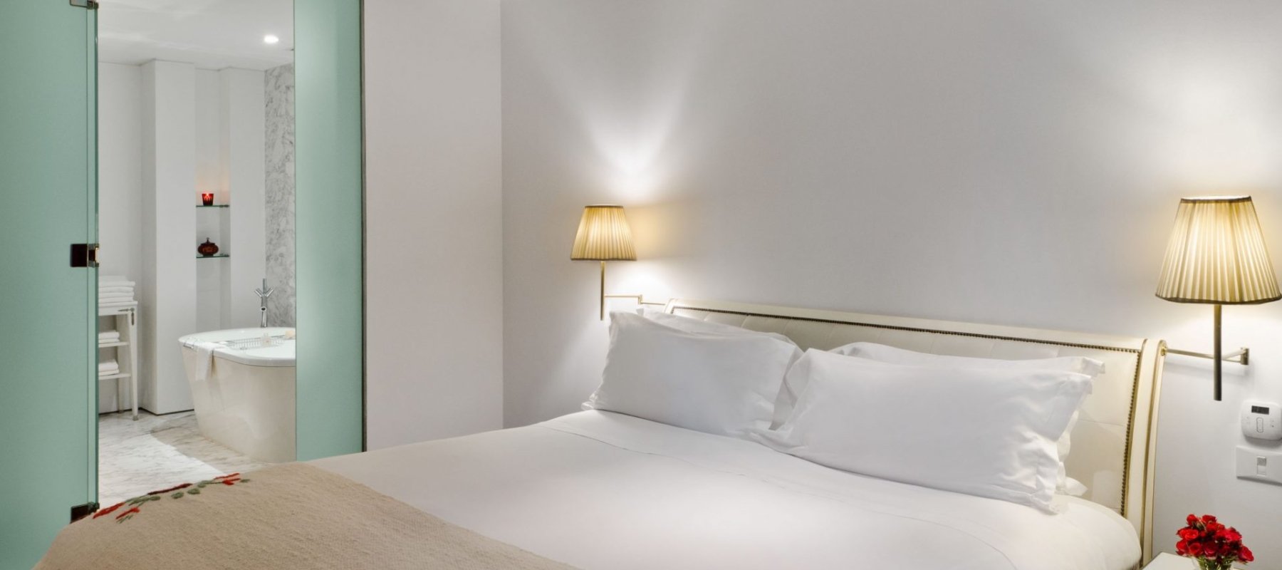 hotel bedroom with bed and door open into the bathroom