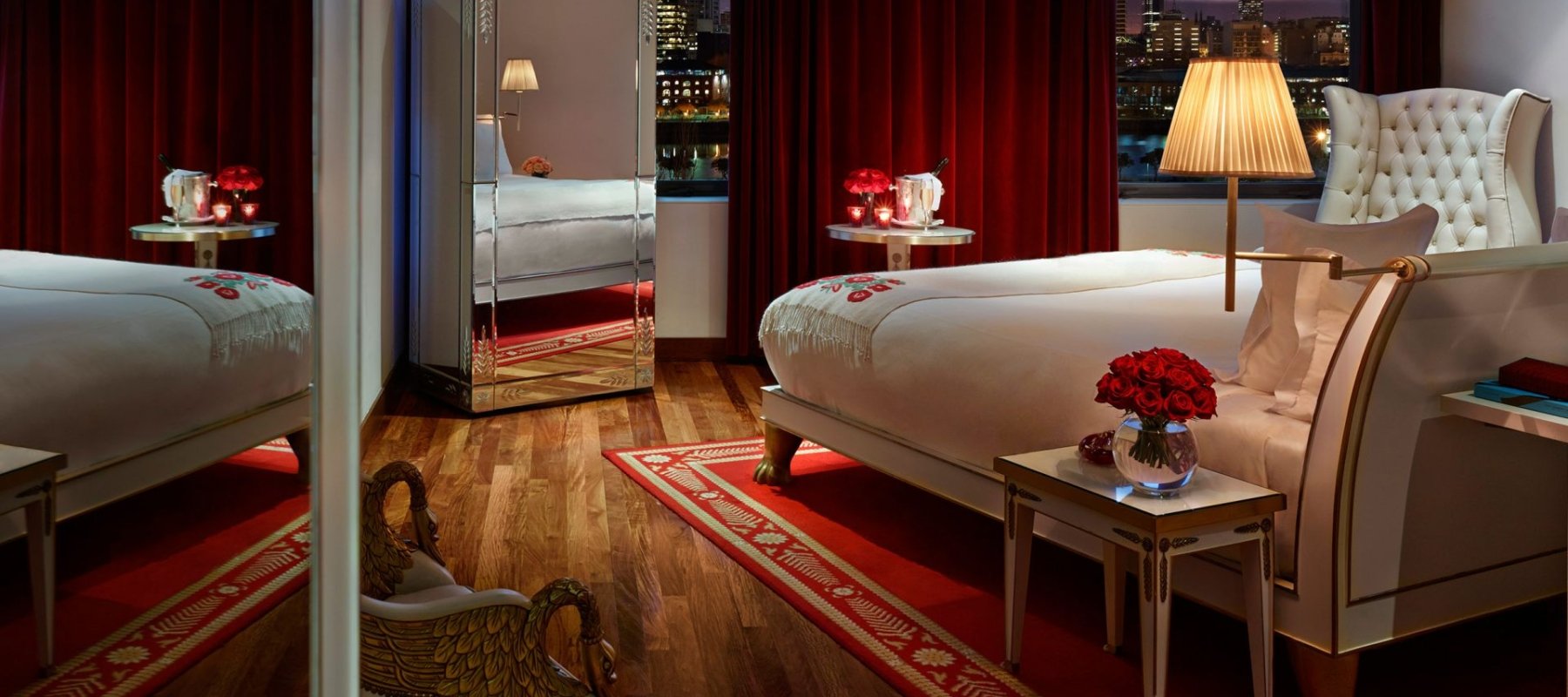 hotel bedroom with large windows overlooking city