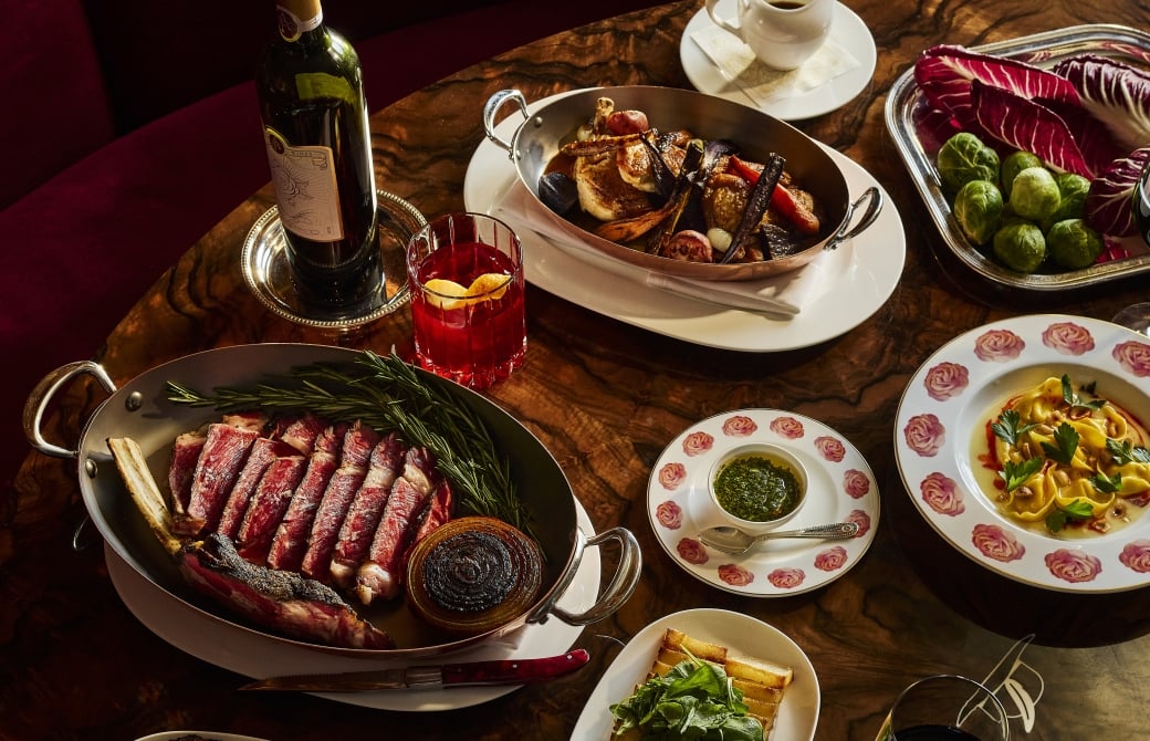 Thanksgiving dishes plated on rose plates with meat and wine