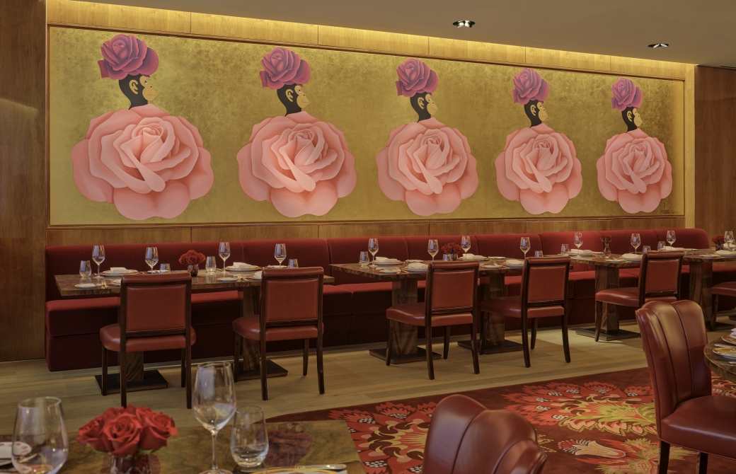 The dining room at La Boca, with gold walls and a mural of white pink roses