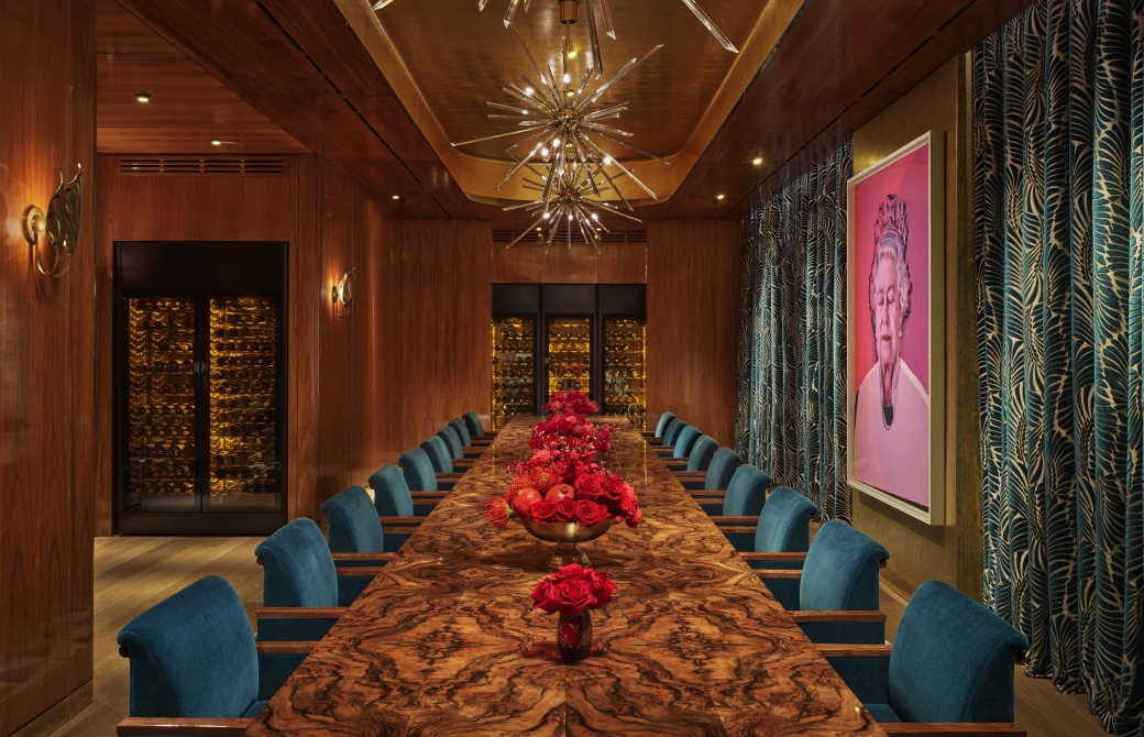 An eclectic private dining room with a long table and a pop art painting of Queen Elizabeth