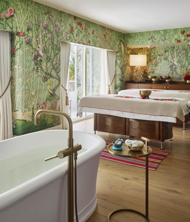 A spa room with a bathtub and massage table