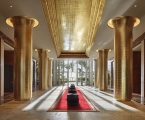 long lobby hallway with six golden columns