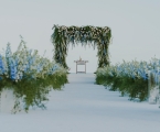 wedding arch made of floral and greenery on beachfront