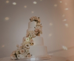 Simple wedding cake with white roses climbing up to the top