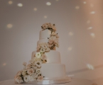 Simple wedding cake with white roses climbing up to the top