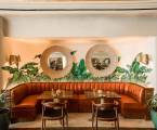 banquette seating dining area with palm leave mural