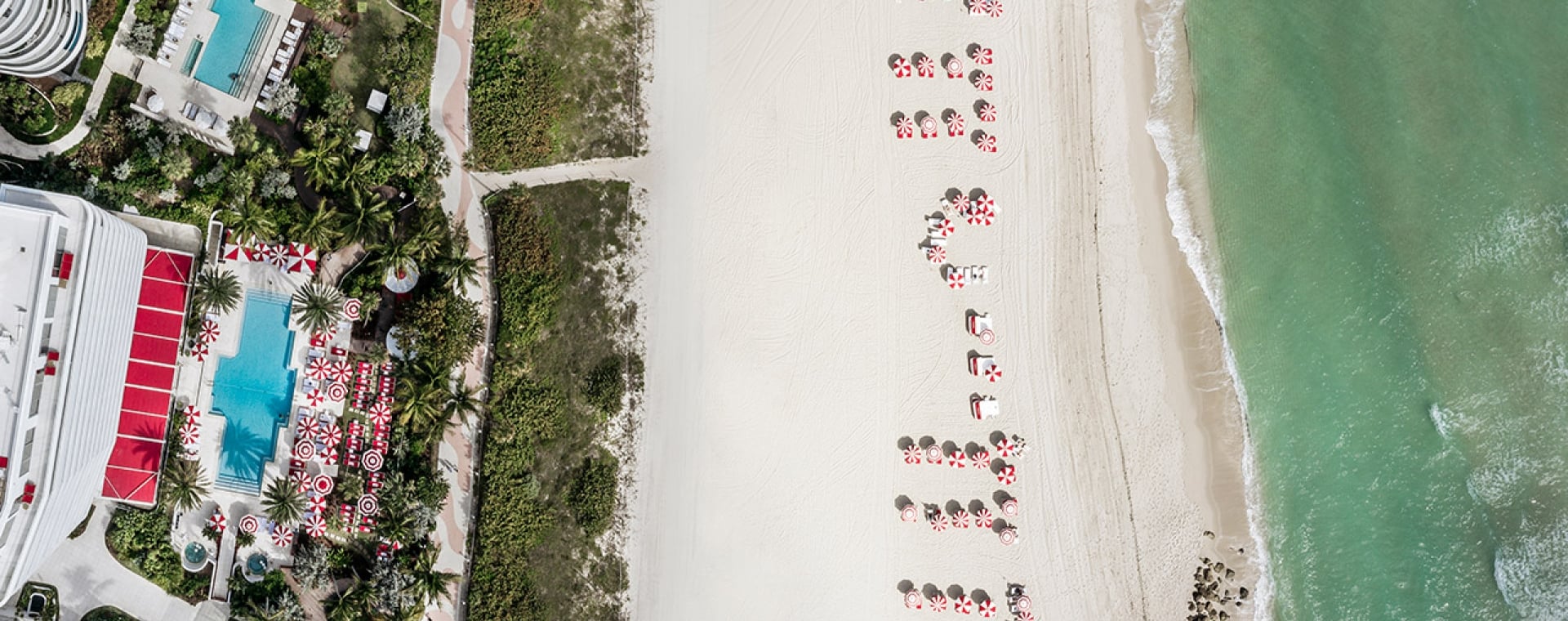 Aerial view of a beach with a hotel and pool area