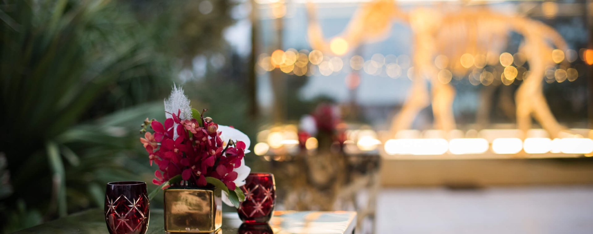 a table with a vase of flowers and glasses