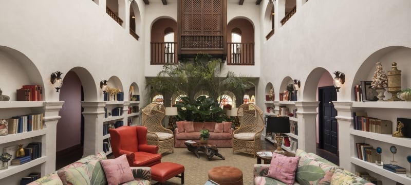 atrium of hotel filled with red, pink, green, and wicker furniture