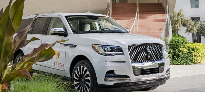 A Lincoln with a Faena decal under a car port