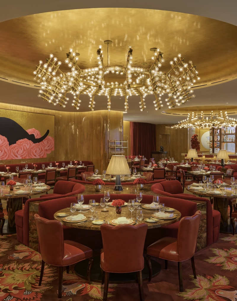 The dining room at La Boca, with gold walls and a mural featuring a black cat
