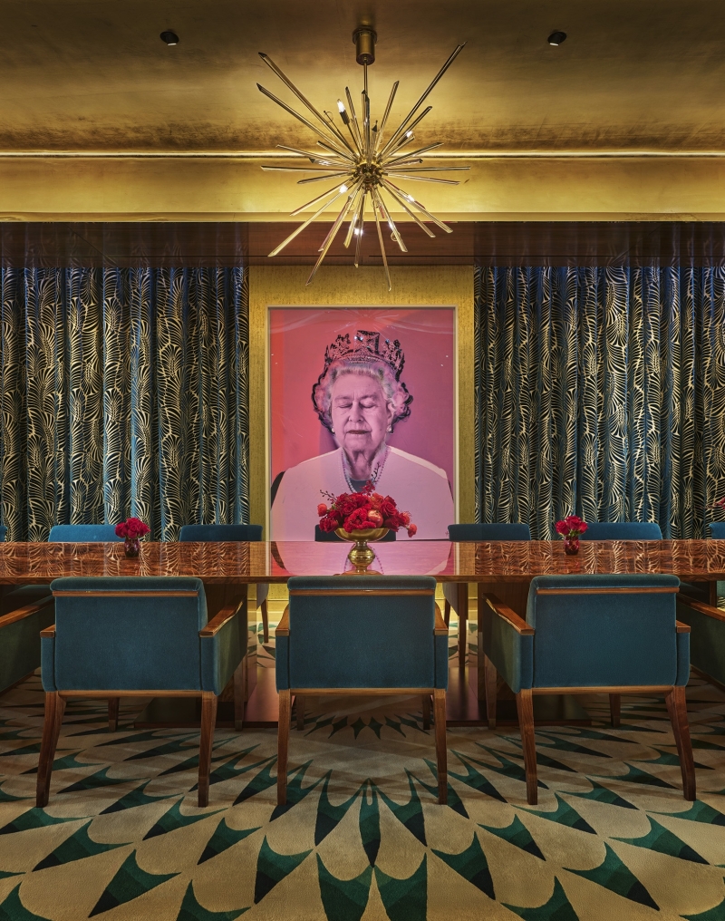 An eclectic private dining room with a long table and a pop art painting of Queen Elizabeth