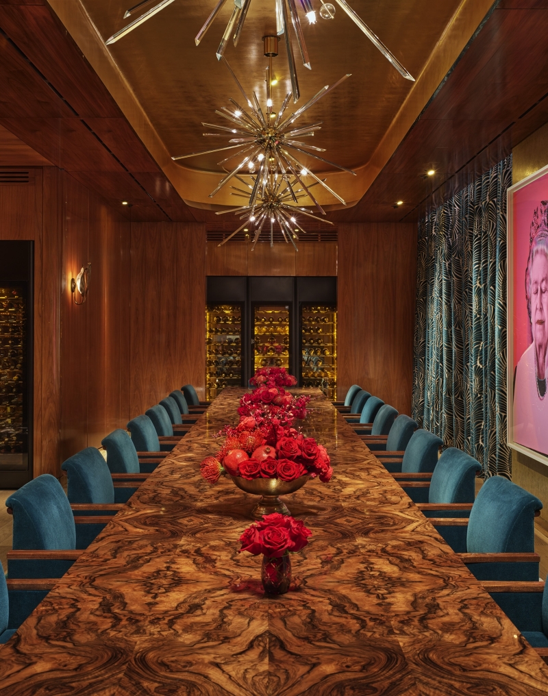 An eclectic private dining room with a long table and a pop art painting of Queen Elizabeth