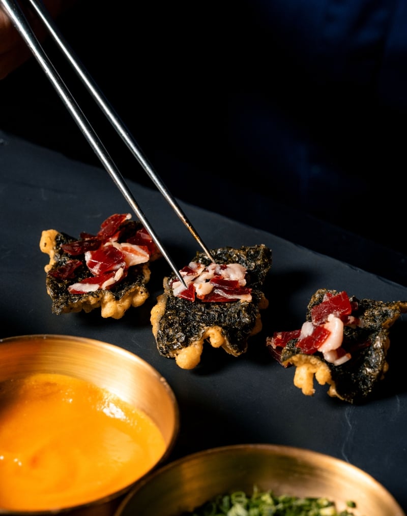 Gourmet crispy canapés with cured meat and savory toppings at El Secreto Omakase