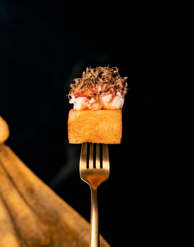 Gourmet seafood canapé topped with shaved truffle, elegantly presented at El Secreto