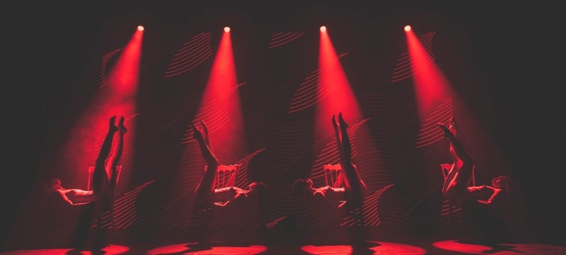 four Tryst Caberet dancers bathed in red spotlights